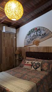 a bedroom with a large bed and a lamp at Paraíso do Ribeirao da Ilha in Florianópolis
