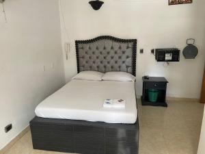 a bedroom with a large bed with a black headboard at Residencias del Oriente in Bucaramanga