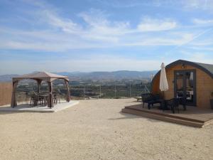 um gazebo com uma mesa e um guarda-chuva em Glamping Pod em Prodhromi