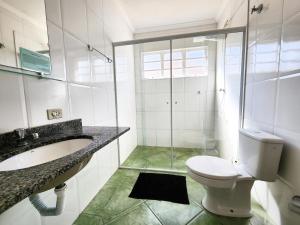 a bathroom with a toilet and a sink and a shower at Quatro Estacoes Hospeda -Vila 01 , sua casa em Campos do Jordao, a 1 km do centro turistico in Campos do Jordão