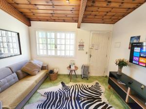 a living room with a couch and a zebra rug at Quatro Estacoes Hospeda -Vila 01 , sua casa em Campos do Jordao, a 1 km do centro turistico in Campos do Jordão