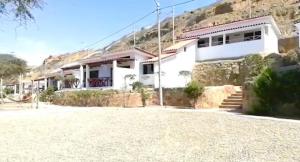 ein weißes Haus auf einem Berg in der Unterkunft Casuarinas Del Mar Chalet de 2 habitaciones in Canoas De Punta Sal