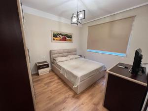 ティラナにあるTirana Deluxe Apartment w/ self Check-In 24hr!のベッドルーム1室(ベッド1台、デスク、テレビ付)