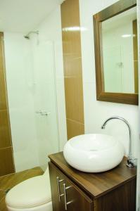 a bathroom with a sink and a toilet and a mirror at CASA HOTEL LOS ARBOLES in Bello