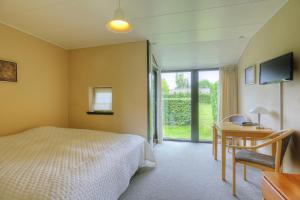 a bedroom with a bed and a table and a desk at The Cottage in Nysted