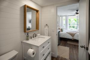 a white bathroom with a sink and a mirror at Walk to Beach from this Renovated Studio with King Bed and Resort-Level Amenities in Wailea +13 photos