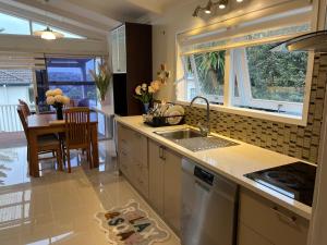 cocina con fregadero y comedor en Hillcrest Homestay, NorthShore, Auckland, en Auckland