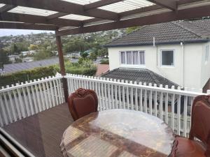 patio ze stołem i krzesłami na balkonie w obiekcie Hillcrest Homestay, NorthShore, Auckland w Auckland