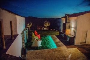 a person sitting in a chair on a patio at Quinta Dos Avós Lourenço in Sertã