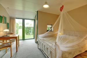 a bedroom with a bed with a mosquito net at The Cottage in Nysted