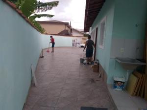 Dos personas están jugando en un pasillo con patinetas en casa na praia Itanhaém, en Guarulhos