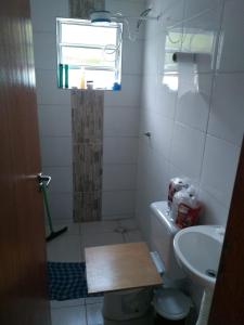 La salle de bains est pourvue de toilettes et d'un lavabo. dans l'établissement casa na praia Itanhaém, à Guarulhos