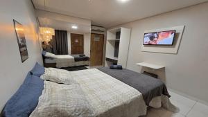 a bedroom with a large bed and a living room at Hotel Manaus - Dom Pedro in Manaus