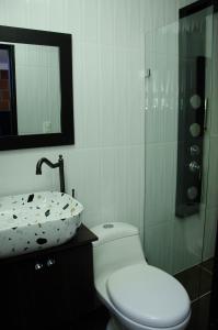 een badkamer met een toilet, een wastafel en een douche bij CASA HOTEL LOS ARBOLES in Bello