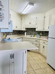 a kitchen with white cabinets and a white counter top at The Chelsea House Villas, Gorgeous condo-OceanView-Jacuzzi in Myrtle Beach