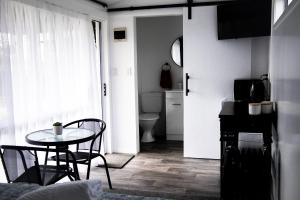 Habitación con mesa y baño. en Rustic Rails Accommodation, en Dargaville