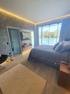 een slaapkamer met een bed en een groot raam bij Reserva do Lago in Avaré