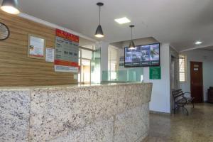 a bar in a restaurant with a tv on the wall at Hotel Terra Cedro In in Goiânia