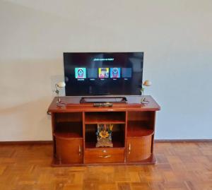 a flat screen tv sitting on top of a wooden entertainment center at Hermoso departamento en Quito con servicios incluidos in Quito