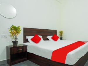ein Schlafzimmer mit einem großen Bett mit roten Kissen in der Unterkunft SPOT ON Hotel Friend's Park in Bhilai