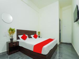 ein Schlafzimmer mit einem großen Bett mit roten Kissen in der Unterkunft SPOT ON Hotel Friend's Park in Bhilai