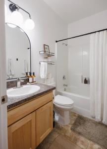 ein Bad mit einem Waschbecken, einem WC und einer Dusche in der Unterkunft Moonstone Acre 3 bedroom with Brand New Spa in Columbia Falls
