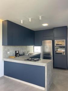a kitchen with blue cabinets and a counter top at Casa Nazar in São Miguel dos Milagres