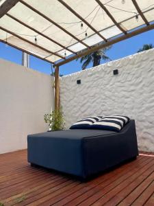 a blue bed sitting on a deck with a roof at Casa Nazar in São Miguel dos Milagres +16 photos