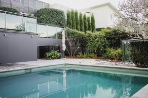 a swimming pool in front of a house at 11 East Gosford Luxury Waterfront House with Private Wharf in Gosford