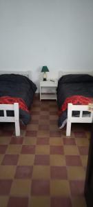 um quarto com 2 camas e um piso em xadrez em HOTEL PARAISO em La Cumbre