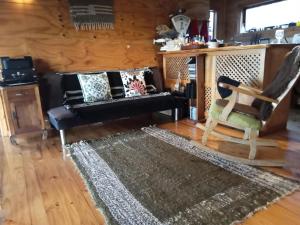 uma sala de estar com um sofá e uma cadeira em CASA PLAYA CHAICURA em Ancud