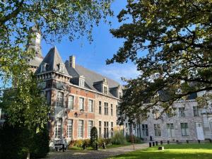 un gran edificio de ladrillo con una torre en Suite Royale Hotel Ferme Du Château Fontaine en Fontaine-lʼÉvêque