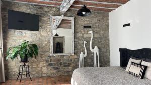 een slaapkamer met een stenen muur, een bed en een spiegel bij Suite Royale Hotel Ferme Du Château Fontaine in Fontaine-lʼÉvêque