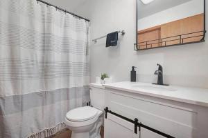 La salle de bains est pourvue de toilettes, d'un lavabo et d'un miroir. dans l'établissement Cozy Cabin at The Poconos With Jacuzzi!, à East Stroudsburg