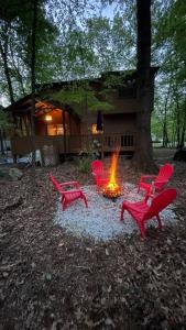 イースト・ストラウズバーグにあるCozy Cabin at The Poconos With Jacuzzi!の火場周囲赤い椅子群