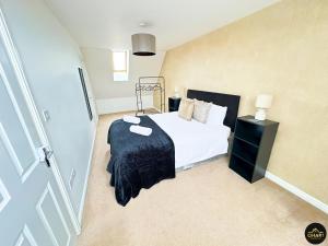 a bedroom with a bed with a black blanket at Modern 3 Bedroom House With FREE Parking in Kenton