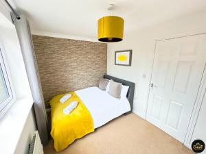 um quarto com uma cama com um cobertor amarelo em Modern 3 Bedroom House With FREE Parking em Kenton
