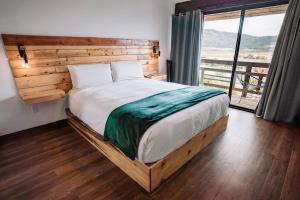 1 dormitorio con 1 cama grande y pared de madera en Finca Selah, en Ensenada