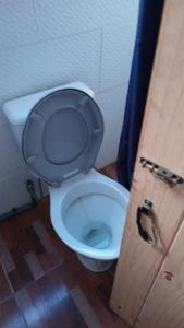 une salle de bain avec WC avec une porte en bois dans l'établissement Mi bus, à Punta del Diablo