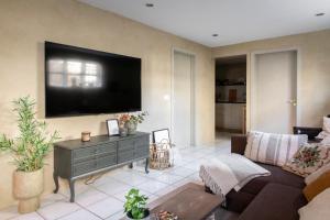 a living room with a couch and a tv on the wall at Old Charm Apartment - Keflavík Downtown in Keflavík