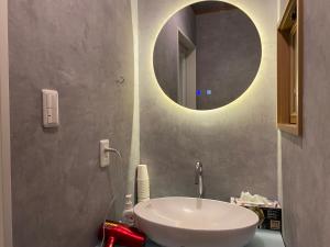 a bathroom with a white sink and a mirror at Numazu Ikyuuan 沼津一休庵 in Numazu