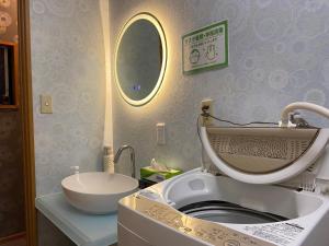 a bathroom with a sink and a toilet and a mirror at Numazu Ikyuuan 沼津一休庵 in Numazu