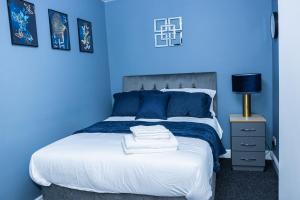 ein blaues Schlafzimmer mit einem Bett mit blauen Wänden in der Unterkunft Lush Lodge -Home away in Telford in Telford