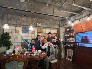 a group of people posing for a picture at a table at HOSTEL OE in Yoshinogawa