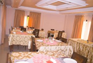 a dining room with tables and chairs in a room at Hotel Murex in Brazzaville