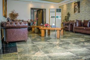 uma sala de estar com mobiliário de couro e uma mesa em Hotel Murex em Brazavile
