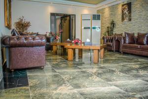 a living room with leather furniture and a table at Hotel Murex in Brazzaville