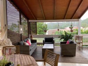 a patio with a couch and chairs and a table at Akaze in Gourbeyre