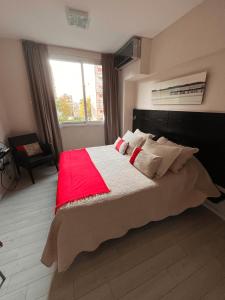 una camera da letto con un grande letto con una coperta rossa di Monoambiente Frente Al Hospital Italiano a Buenos Aires