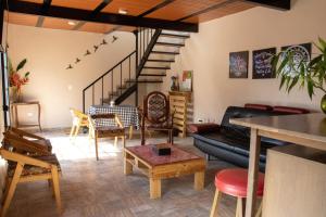 a living room with a couch and a staircase at Bio-Hotel entre café, bosque y montañas in Cachipay